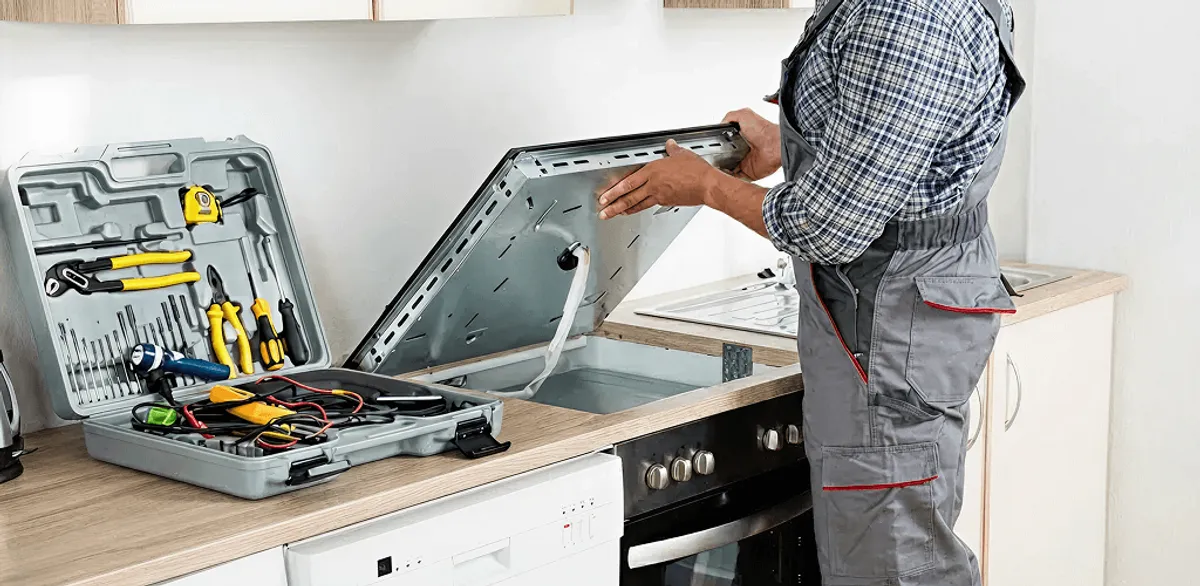 Handyman repairing a cooktop and checking wiring connections in Lowell, MA