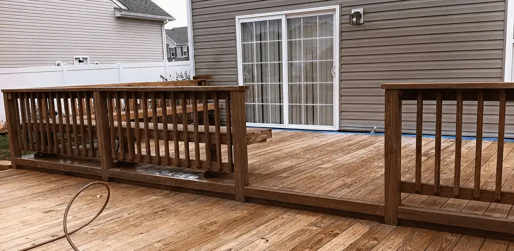 Deck sealing service protecting a backyard wood deck and railings in Lowell, MA