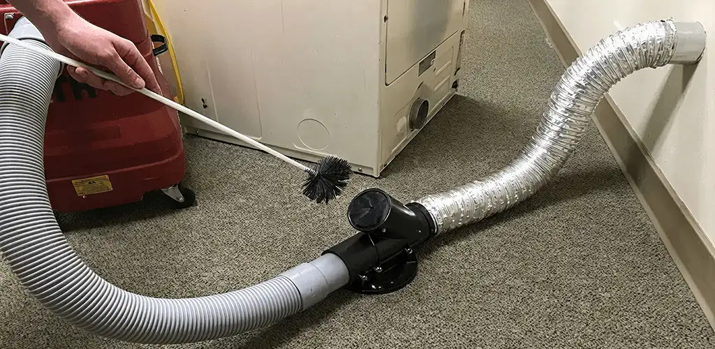 Dryer vent cleaning service removing lint from a dryer duct connection in Lowell, MA