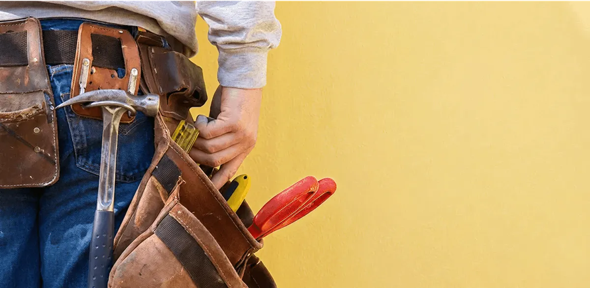 Handyman with tool belt ready for home repairs and maintenance in Lowell, MA