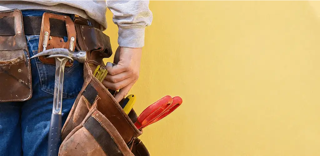 Handyman with tool belt ready for home repairs and maintenance in Lowell, MA
