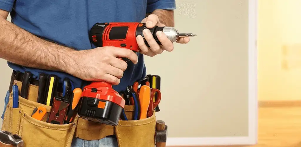 Handyman holding a power drill for home repairs and installations in Lowell, MA