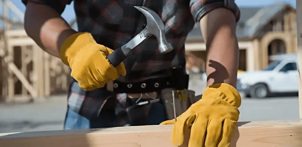 Handyman fixing wood trim with a hammer for home repairs in Lowell, MA