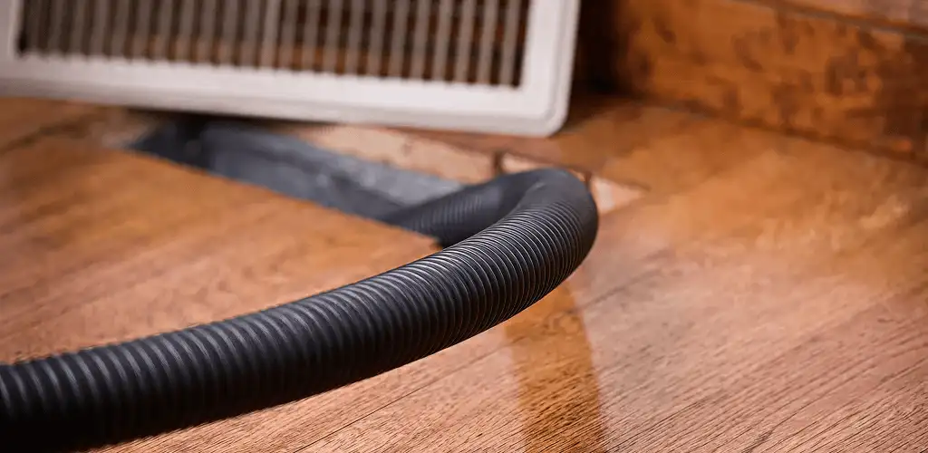 Air duct cleaning hose inserted into a floor vent for ductwork cleaning in Lowell, MA