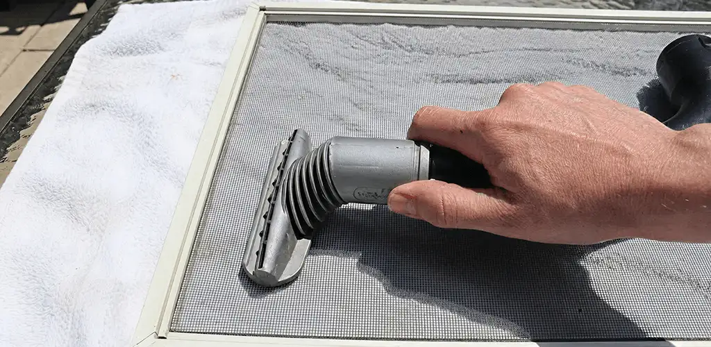 Window screen repair cleaning and fixing a damaged screen mesh in Lowell, MA
